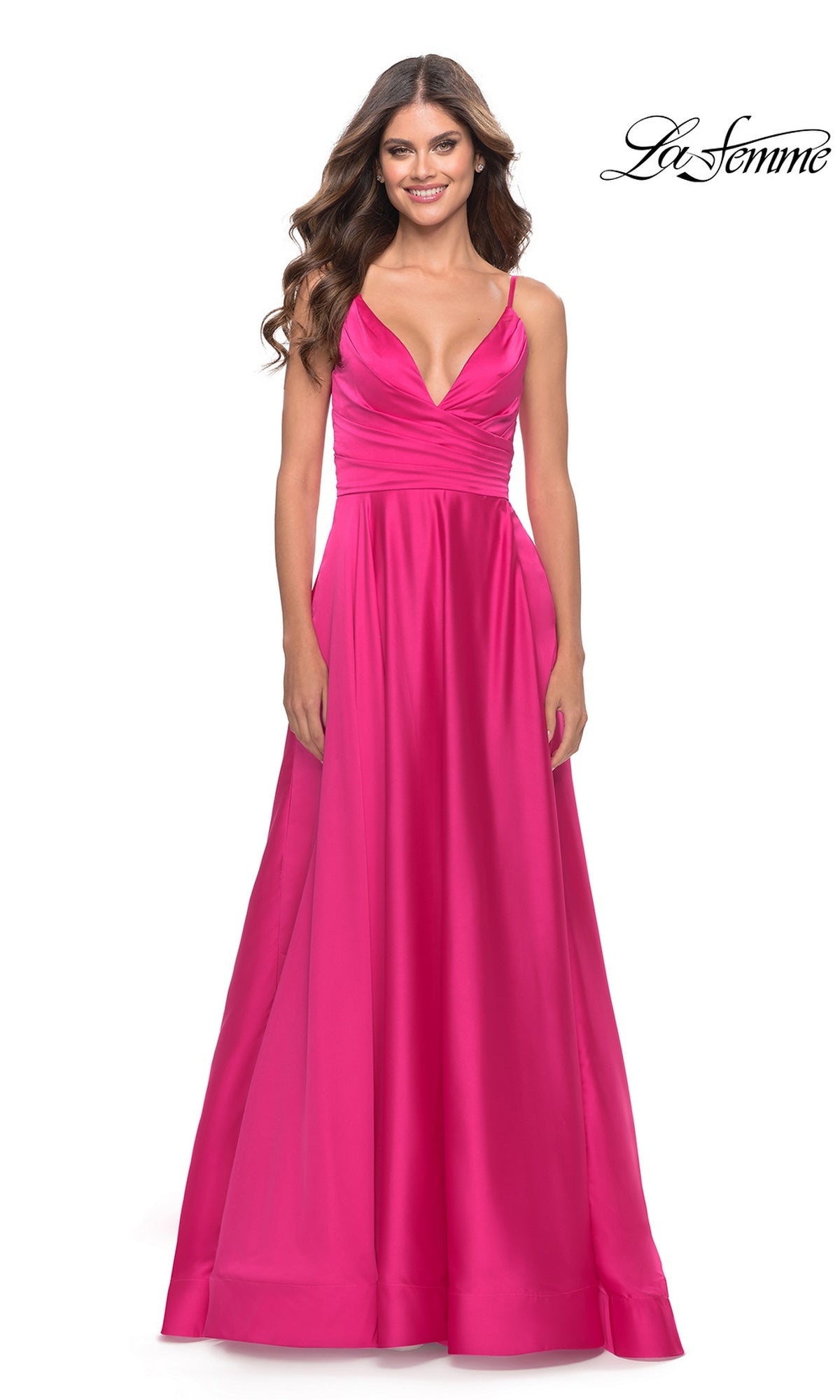 A woman in the La Femme Bright Long A-Line Prom Dress 31121, featuring spaghetti straps and a deep V neckline, stands smiling against a plain white background.